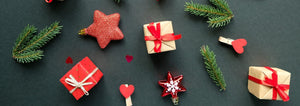 Christmas gifts, pine sprigs, and ornaments on dark background