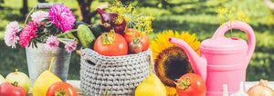 flowers and vegetables sitting on a table outside