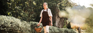 Woman walking down a dirt road carrying a basket